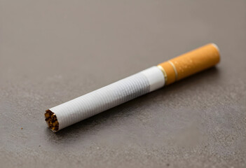 Obraz premium Single unlit cigarette with a filter and tobacco on a textured gray surface, addiction and health risks