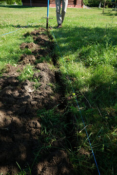 Digging a trench in the backyard lawn along the marking line