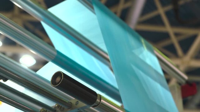 Automatic polyethylene plastic bag production machine with lighting effect. Close-up of the roller of the plastic bag production machine in the light blue scene. product packaging concept