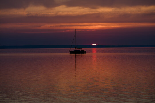 Sunrise over Lake Balaton with sailboat silhouette near the Tihany Peninsula, Hungary