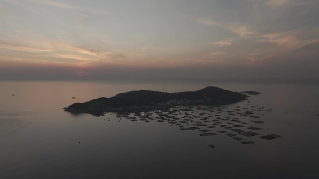 Aerial drone footage of sunrise over Binh Hung Island and its stunning coastline in Khanh Hoa, Vietnam, featuring turquoise waters, rocky shores and breathtaking tropical seascapes.
