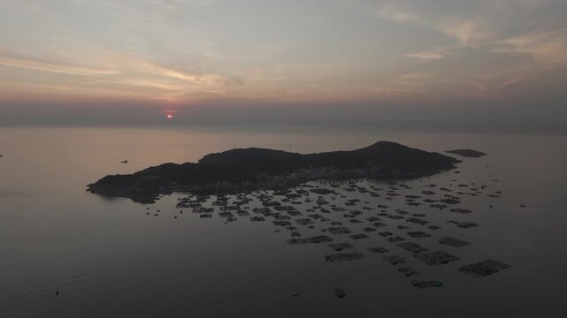 Aerial drone footage of sunrise over Binh Hung Island and its stunning coastline in Khanh Hoa, Vietnam, featuring turquoise waters, rocky shores and breathtaking tropical seascapes.