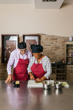 Chefs preparing ingredients during cooking course in restaurant kitchen