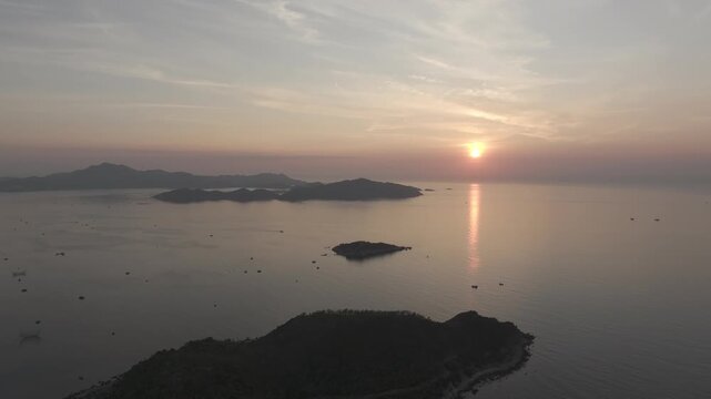 Aerial drone footage of sunrise over Binh Hung Island and its stunning coastline in Khanh Hoa, Vietnam, featuring turquoise waters, rocky shores and breathtaking tropical seascapes.