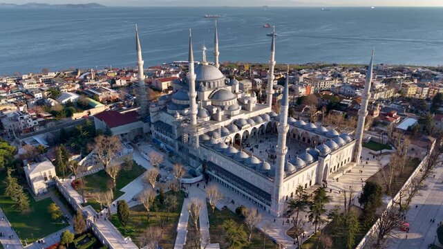 Beautiful aerial view of the iconic Blue Mosque (Sultan Ahmed Mosque) in Istanbul, Turkey, captured during golden hour. The historic Ottoman mosque dominates the skyline with its six elegant minarets 