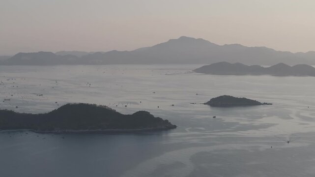 Aerial drone footage of sunrise over Binh Hung Island and its stunning coastline in Khanh Hoa, Vietnam, featuring turquoise waters, rocky shores and breathtaking tropical seascapes.