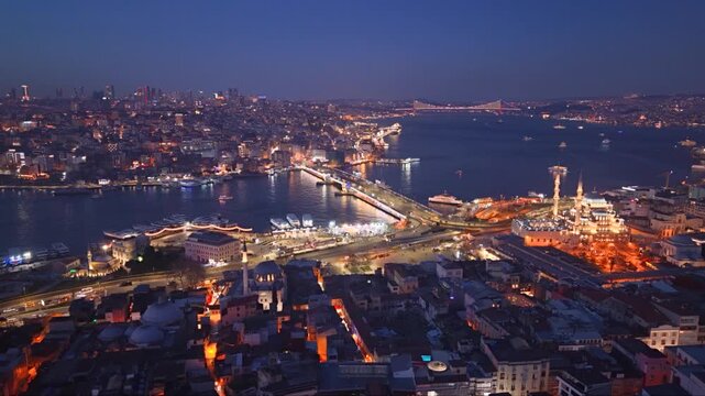 Aerial twilight view of Istanbul, Turkey, overlooking the Golden Horn and Bosphorus with illuminated waterfront roads, historic mosques, dense urban neighborhoods and a suspension bridge glowing in th