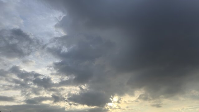 Dramatic dark storm clouds fill the sky with sun breaking through