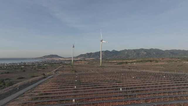 Aerial drone footage of Wind Farm in Phuoc Dinh, Khanh Hoa, Vietnam, featuring giant wind turbines along the coastal landscape, showcasing renewable energy, sustainable power and clean technology.