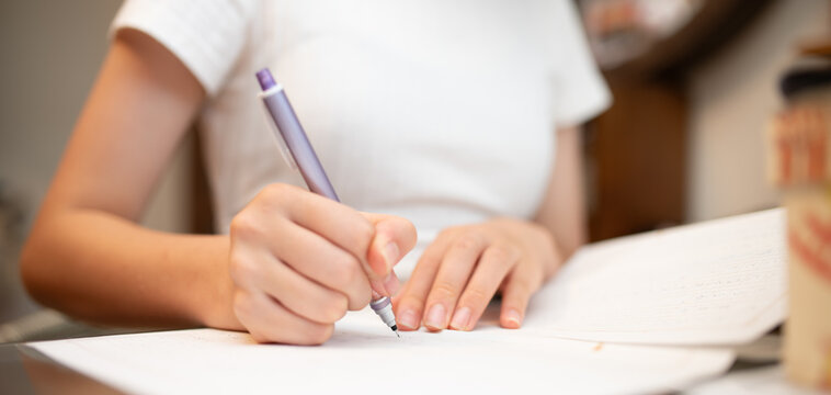 ノートに向かい集中してテスト勉強や学習をする学生の手元
