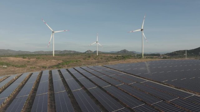 Aerial drone footage of Phuoc Dinh Renewable Energy Complex in Khanh Hoa, Vietnam, featuring solar panels and wind turbines, showcasing clean energy, sustainable power and green technology.