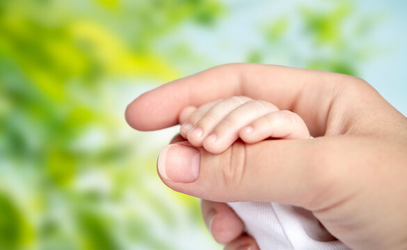 Newborn baby holding adult finger tightly for emotional connection with grasping affection protection fingertip clutching