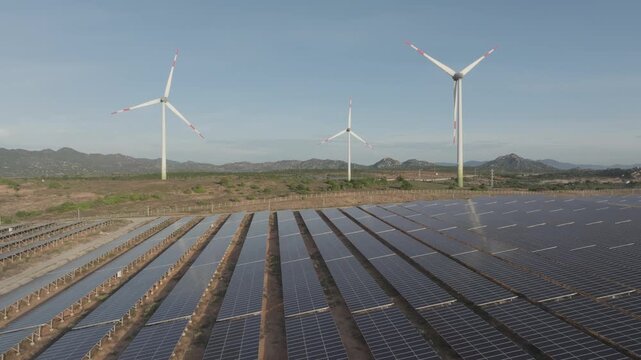 Aerial drone footage of Phuoc Dinh Renewable Energy Complex in Khanh Hoa, Vietnam, featuring solar panels and wind turbines, showcasing clean energy, sustainable power and green technology.