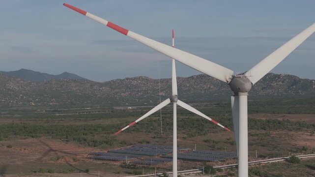 Aerial drone footage of Wind Farm in Phuoc Dinh, Khanh Hoa, Vietnam, featuring giant wind turbines along the coastal landscape, showcasing renewable energy, sustainable power and clean technology.
