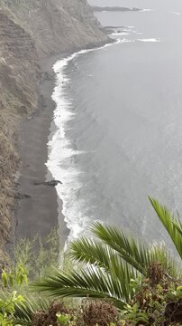 Vertical Shot capturing the Dramatic Atlantic Ocean Scenery from Mirador los 500 Escalones in Tenerife, Canary Islands. Windy Coastal Landscape with Sea, Palm Tree and Steep Cliffside Views.