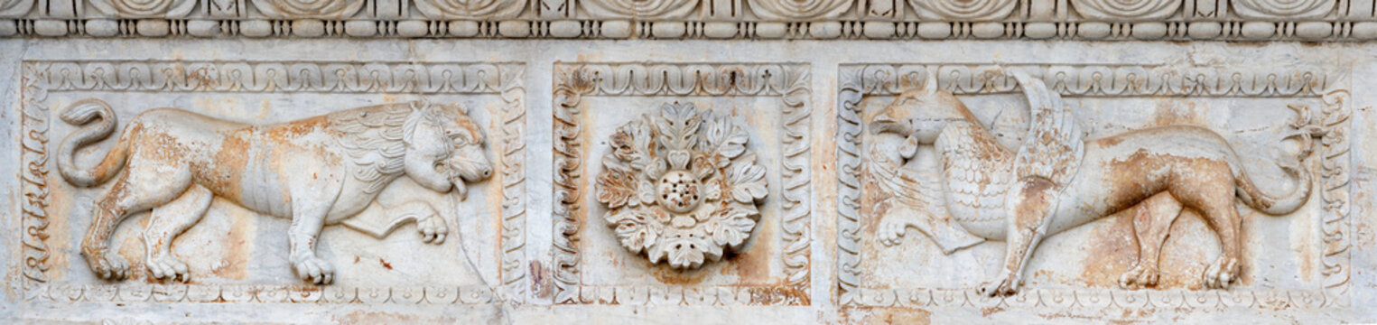 Lucca - The detail of relief over the side (lions) potal of church Chiesa di Santa Maria Fortisportam by local workroom from 12. cent. 