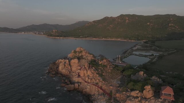 Aerial drone footage of sunrise at Hang Rai, Khanh Hoa, Vietnam, featuring dramatic rocky coastline, turquoise sea, coral reef, golden morning light and breathtaking coastal landscape.