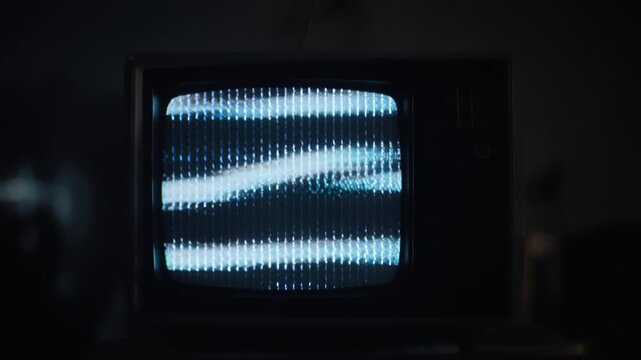 Vintage television with static screen in dark room