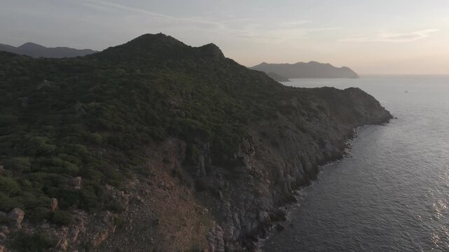 Aerial drone footage of sunrise at Hang Rai, Khanh Hoa, Vietnam, featuring dramatic rocky coastline, turquoise sea, coral reef, golden morning light and breathtaking coastal landscape.