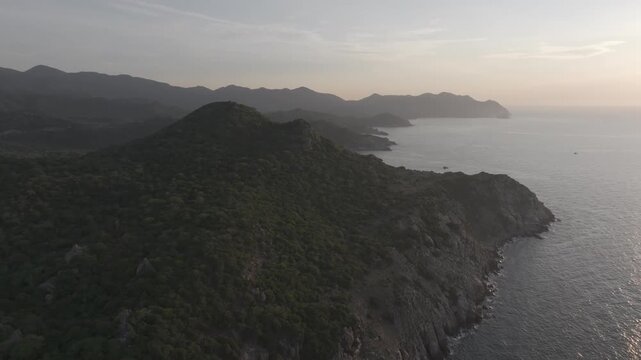 Aerial drone footage of sunrise at Hang Rai, Khanh Hoa, Vietnam, featuring dramatic rocky coastline, turquoise sea, coral reef, golden morning light and breathtaking coastal landscape.