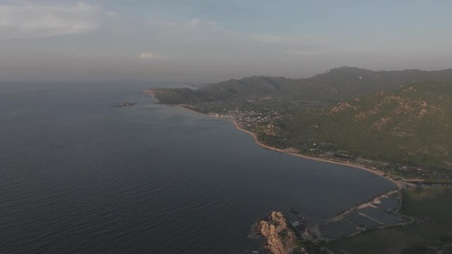 Aerial drone footage of sunrise at Hang Rai, Khanh Hoa, Vietnam, featuring dramatic rocky coastline, turquoise sea, coral reef, golden morning light and breathtaking coastal landscape.