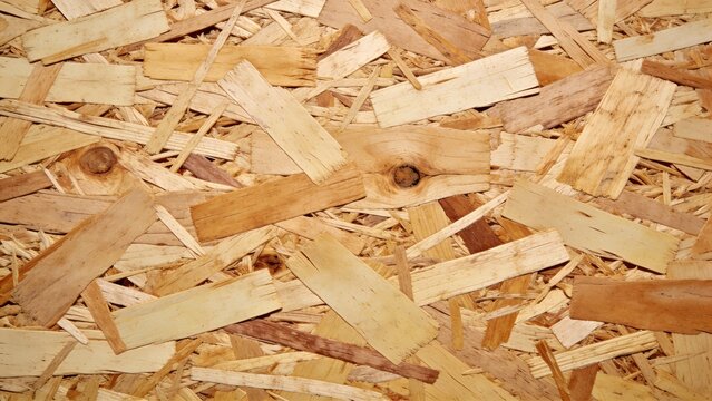 texture of oriented strand board (OSB), a type of engineered wood. The layout is a seamless pattern, showcasing a uniform surface with interwoven wood strands. The strands vary in size and shape, crea