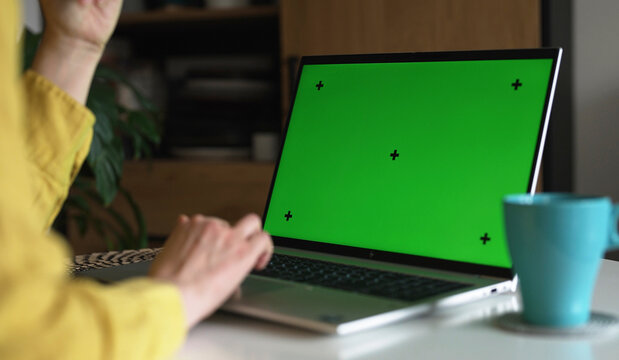 Laptop with green screen chroma key mockup for content replacement.