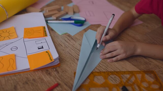 Boy, constructing a paper airplane in a cozy home setting. creative thinking in children.