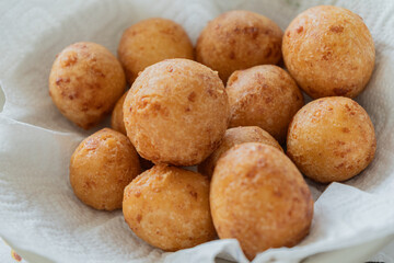 Fototapeta premium Traditional Colombian Buñuelos – Golden Fried Cheese Bread Balls Made with Cassava Flour. Served warm in a paper-lined basket, these crispy-on-the-outside, soft-on-the-inside pastries 
