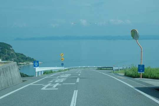 瀬戸内海の青い海と島なみを望むエモーショナルな海岸沿いの道路