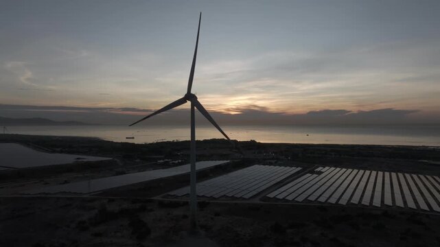 Solar panels and wind turbines in Phuoc Dinh, Khanh Hoa ( Ninh Thuan ) Vietnam. Aerial view of green energy hybrid farm, renewable power generation, and sustainable landscape.