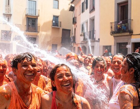 Volunteer spraying water onto participants after La Tomatina Festival in Bu&ntilde;ol, Spain during post-event street cleanup.