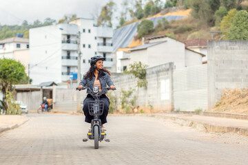 Naklejka premium Young Black Brazilian woman riding an electric bicycle during her daily commute, representing modern urban mobility, practical transportation, and sustainable mobility.