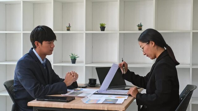 Young Asian business colleagues shaking hands after successful office meeting and agreement