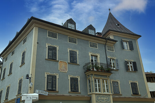 The historic building houses the fawa Shoes store in the center. The facade features a fresco and a characteristic bay window  the store is located in Piazza Maria Hueber 2 Bressanone Italy