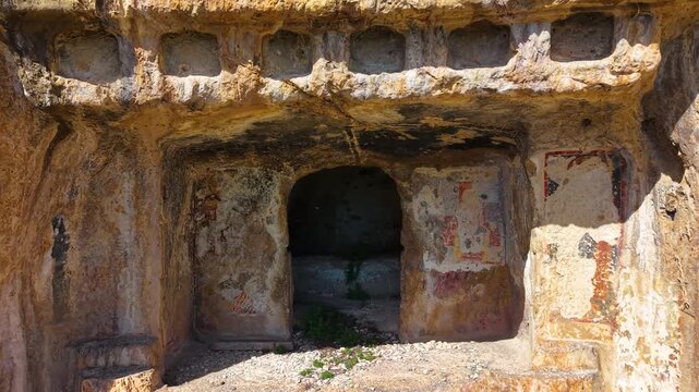 Cinematic close-up approach of a massive, intricately carved ancient royal tomb hewn into fortress stone walls. Ideal for historical exploration.