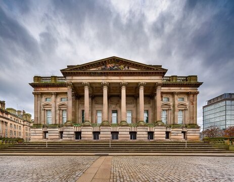 neoclassical civic building with stone columns and balustrade on a wide paved street in liverpool uk showing historic architecture and overcast sky