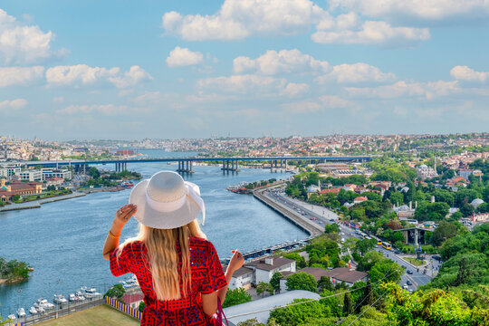 Back view of female tourist wearing sun hat looking at Golden Horn view from Pierre Loti Hill in İstanbul, Turkey