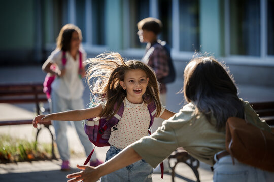 Mother greets daughter in schoolyard