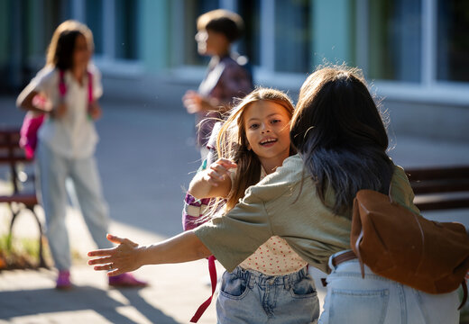 Mother greets daughter in schoolyard