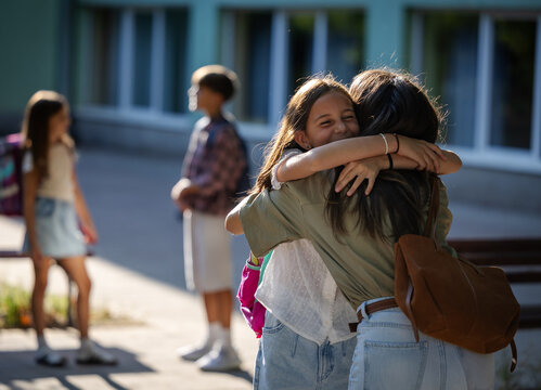 Mother greets daughter in schoolyard