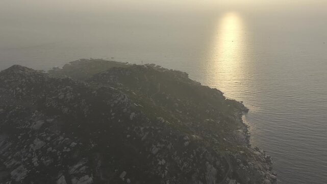 Aerial drone footage of sunrise over Mui Dinh Lighthouse and pristine beach in Khanh Hoa, Vietnam, showcasing golden morning light, dramatic coastline, turquoise sea and iconic coastal landmark.