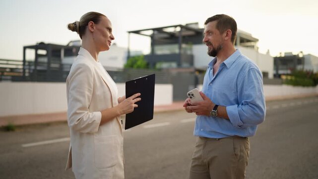 Successful real estate transaction showing a female agent handing over the keys to a new property to a happy male client, who shakes her hand to confirm the purchase of their new home