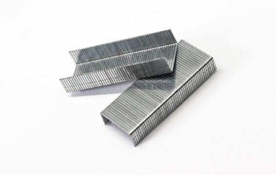 Silver Staples Stacked on White. Macro View of Metal Staples Arranged closely