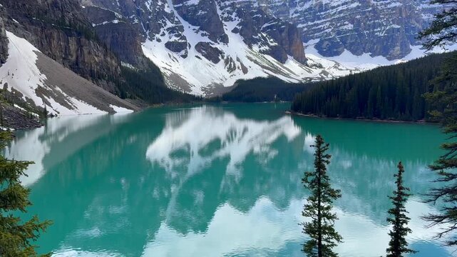 Beautiful view on the Moraine Lake in National Park of Banff, Canada. Stunning view of a mountain lake with turquoise water reflecting surrounding peaks and trees, showcasing the natural beauty.