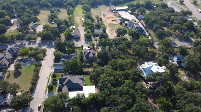Dense tree canopies weave between suburban rooftops, grassy expanses, commercial corridors. Woodlands stretch across community, bridging gap between neighborhoods thoroughfares, Irving, TX