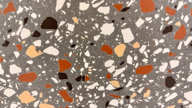 High-resolution close-up of a terrazzo-style ceramic floor tile featuring colorful natural stone fragments embedded in a grey surface
