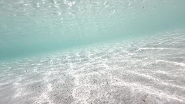 Diagonal close up underwater sandy seabed with light streaks in shallow turquoise ocean, natural marine background, 4K_4_IMG_5273_20s_0,48