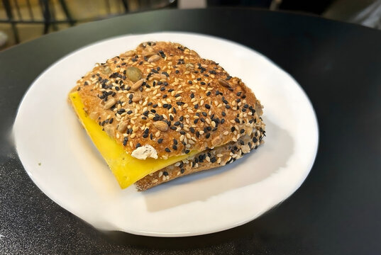 Whole Grain Sandwich with Slice of Yellow Cheese on White Plate