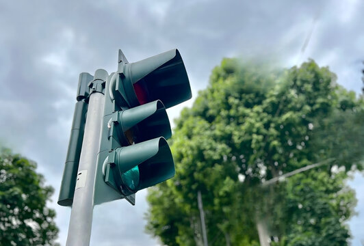Green Traffic Light Against Cloudy Sky and Trees